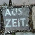 Pflasterstein mit der Aufschrift AUSZEIT zwischen anderen Steinen