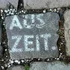 Pflasterstein mit der Aufschrift AUSZEIT zwischen anderen Steinen