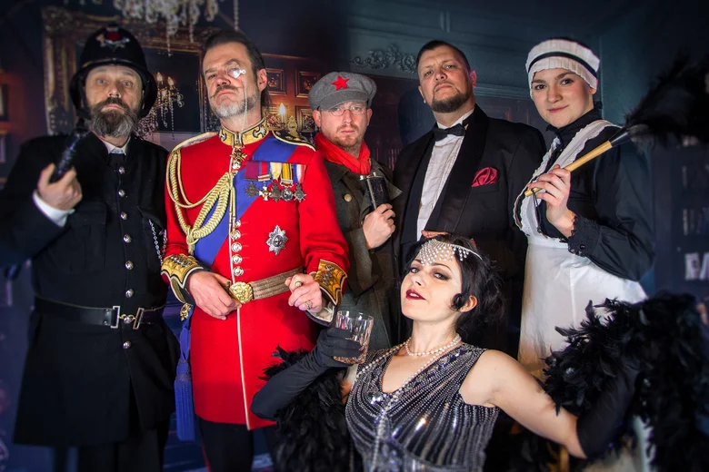 Gruppe in historischen Kostümen posiert in einem prunkvollen Raum