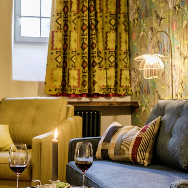 Gemütliches Wohnzimmer mit zwei Sofas, Kerze, Wein und Dominosteinen auf Tisch