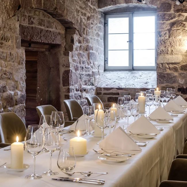 Eleganter Essraum mit Steinmauern, Kerzenlicht und gedecktem Tisch