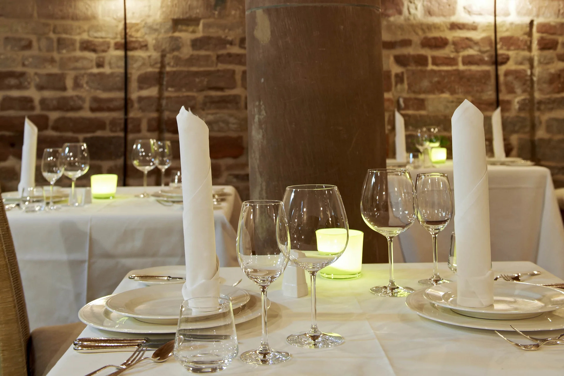 Elegantes Restaurant mit gedeckten Tischen und Steinpfeiler im Innenraum