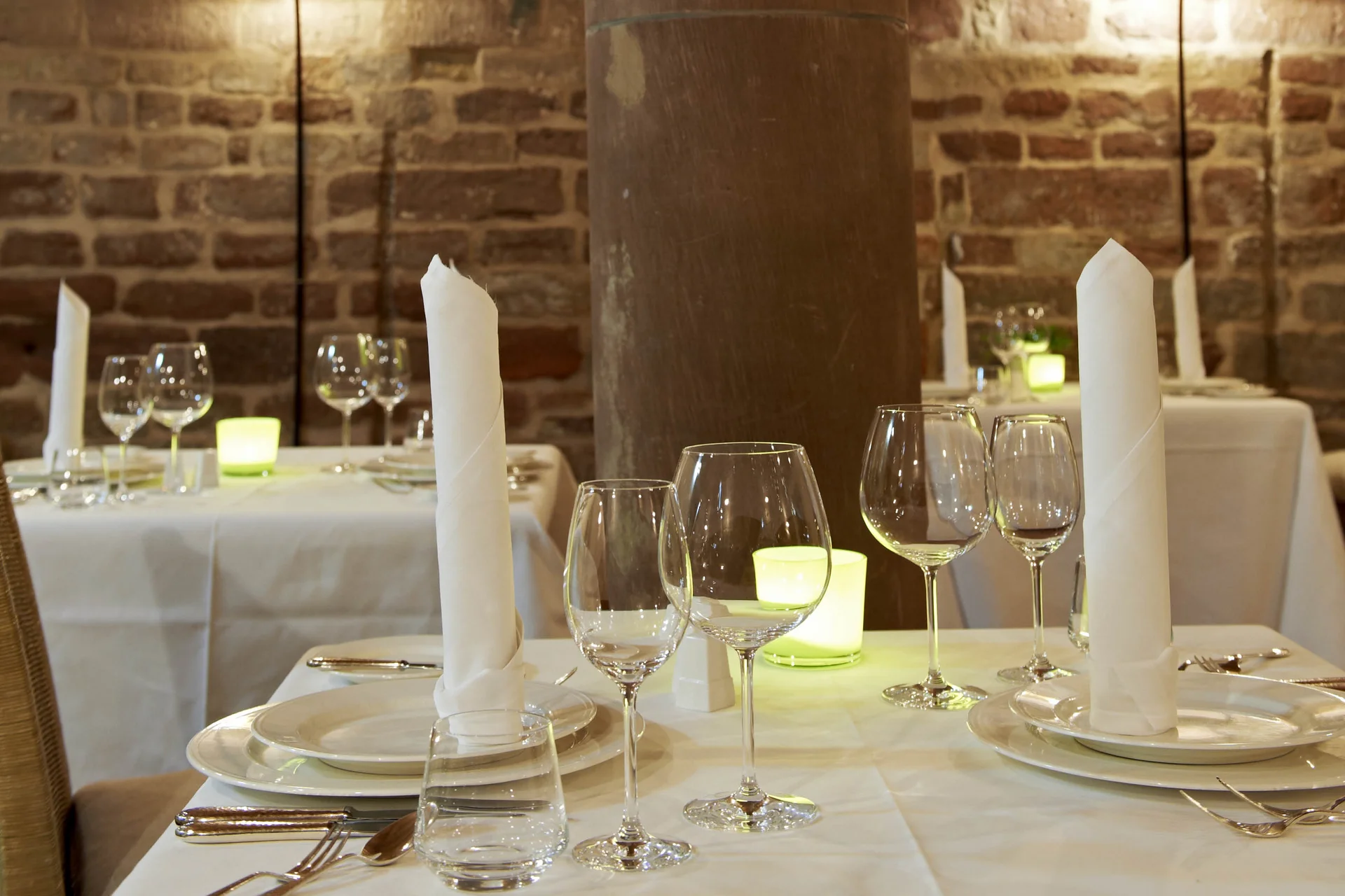 Elegantes Restaurant mit gedeckten Tischen und Steinpfeiler im Innenraum
