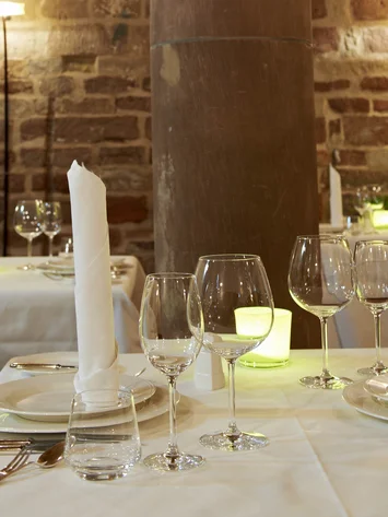 Elegantes Restaurant mit gedeckten Tischen und Steinpfeiler im Innenraum