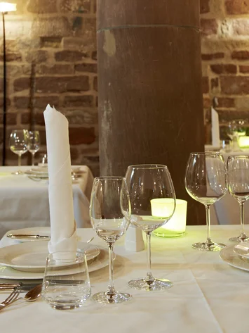 Elegantes Restaurant mit gedeckten Tischen und Steinpfeiler im Innenraum