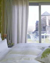 Hotelzimmer mit Balkon und Blick auf historische Burgmauer