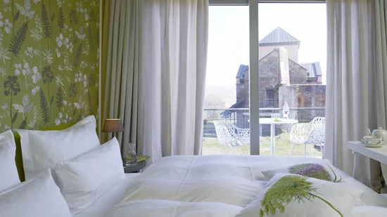 Hotelzimmer mit Balkon und Blick auf historische Burgmauer