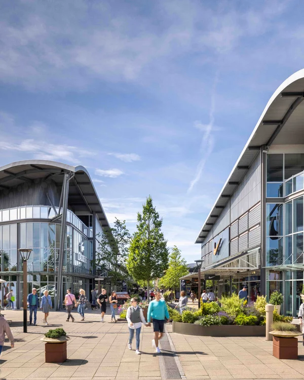 Belebtes Einkaufszentrum mit Lacoste und Nike Geschäften und vielen Spaziergängern