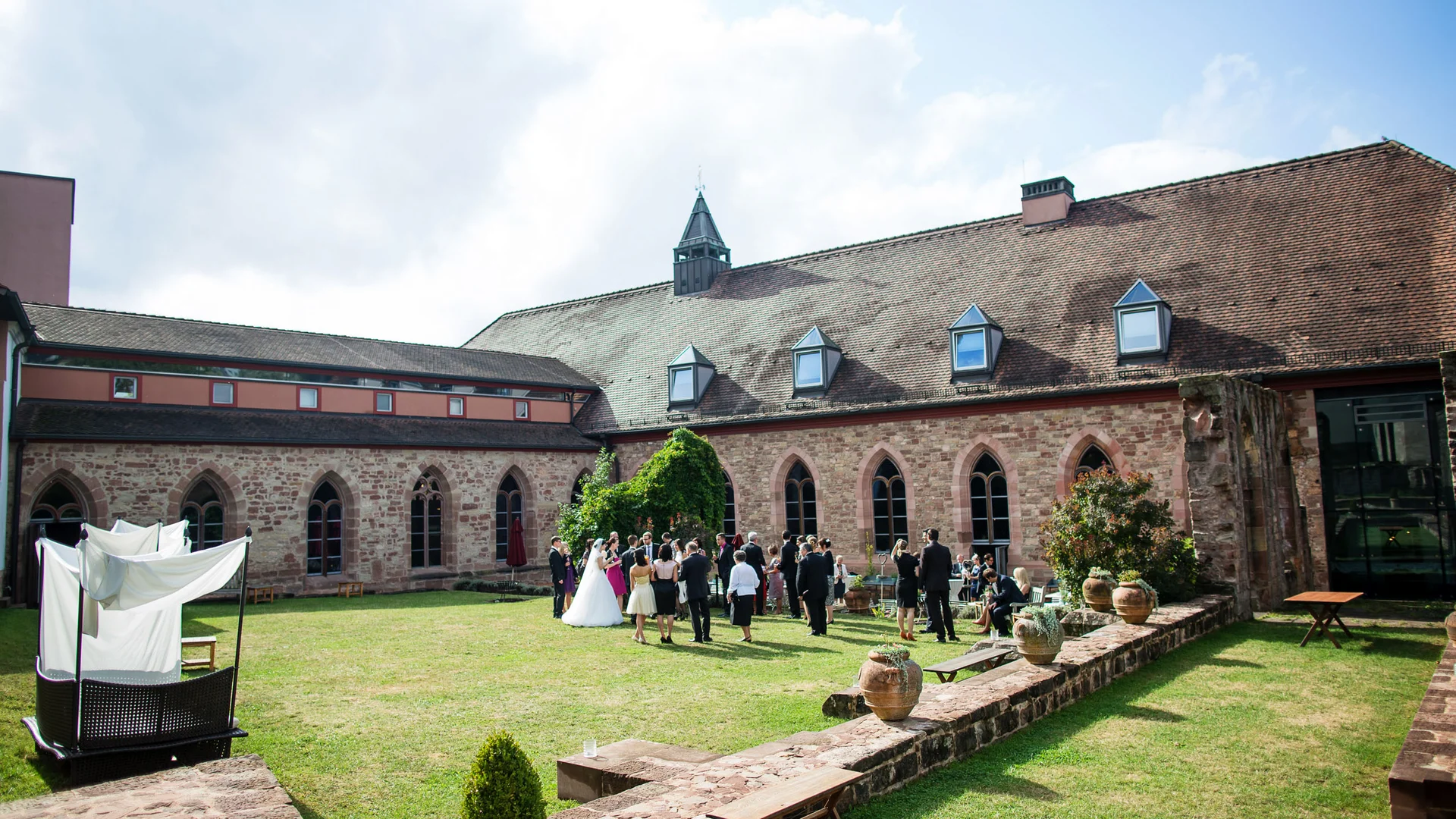Gäste bei einer Hochzeitsfeier im Innenhof eines historischen Gebäudes