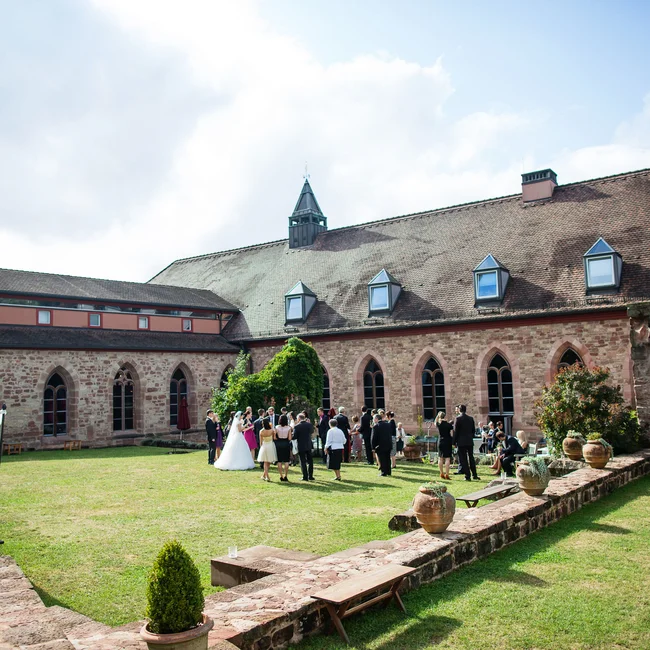Gäste bei einer Hochzeitsfeier im Innenhof eines historischen Gebäudes