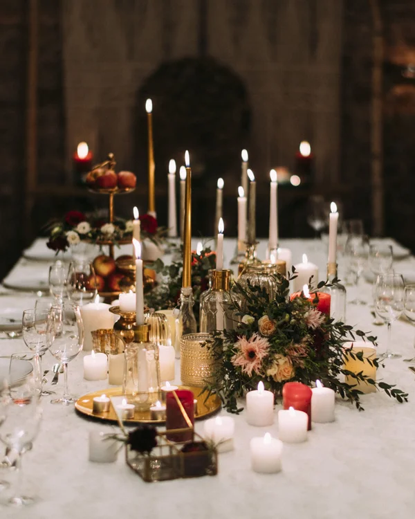 Eleganter gedeckter Tisch mit leuchtenden Kerzen und Blumenarrangements