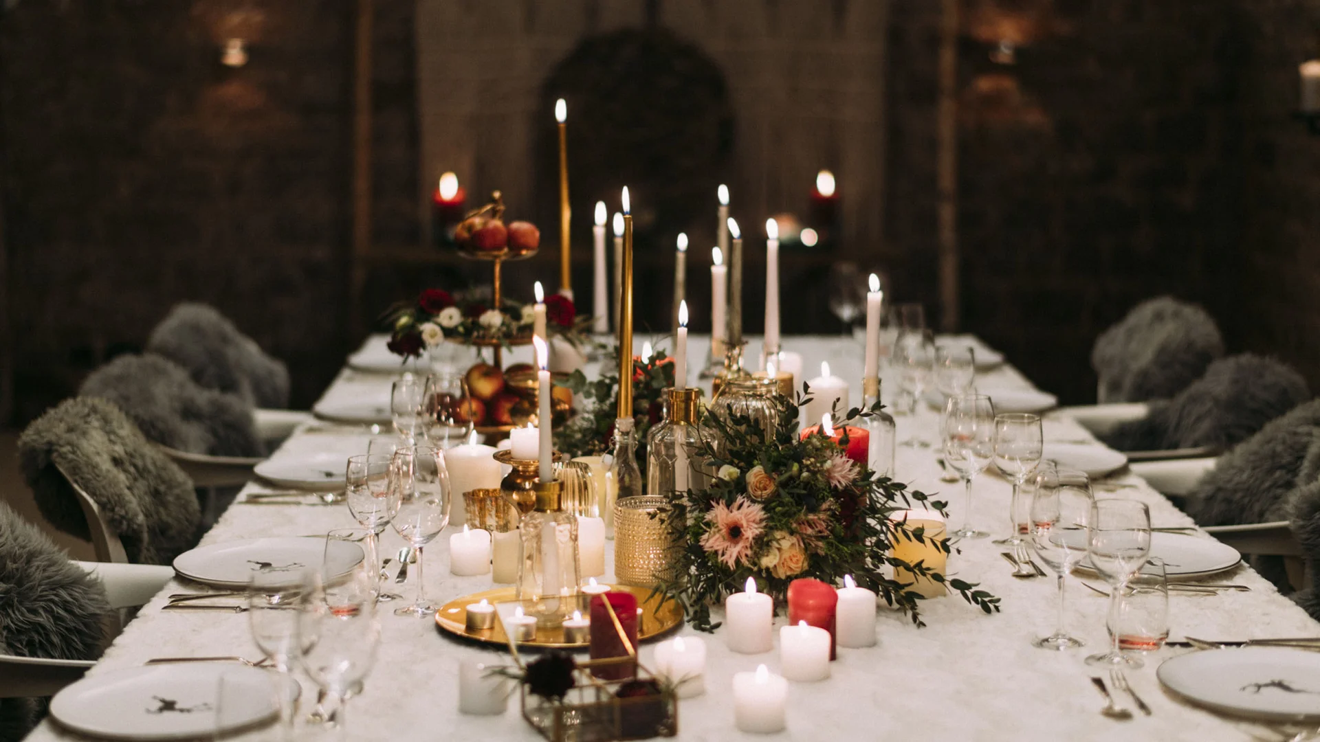 Eleganter gedeckter Tisch mit leuchtenden Kerzen und Blumenarrangements