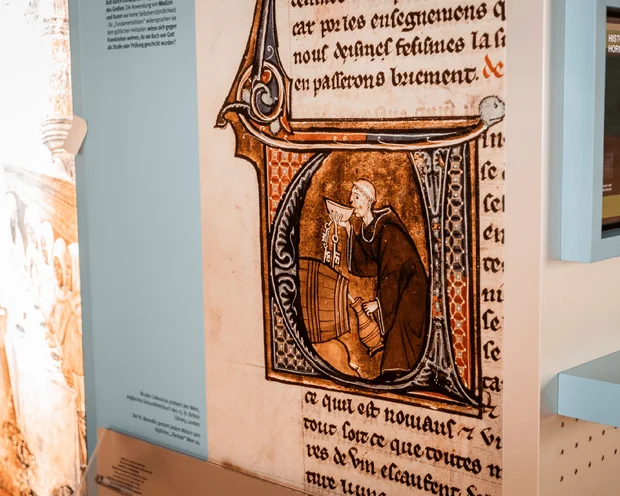 Mittelalterliche illuminiert Manuskriptseite mit einem Mönch und Text im Klostermuseum