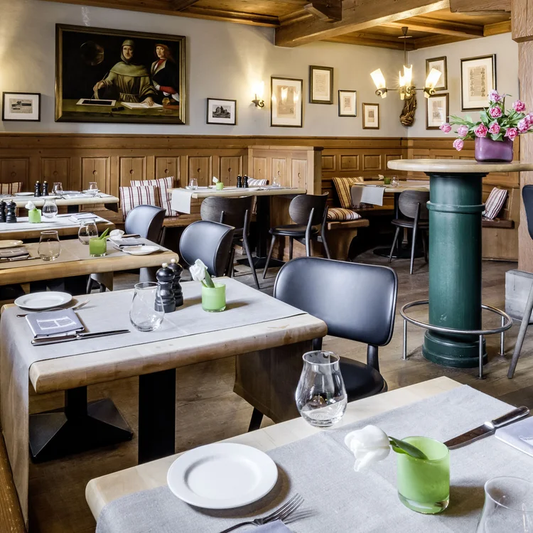 Gemütliches Restaurant mit Holzmöbeln, Barbereich und gedeckten Tischen