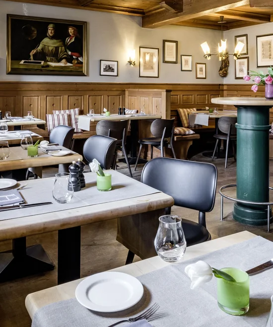 Gemütliches Restaurant mit Holzmöbeln, Barbereich und gedeckten Tischen