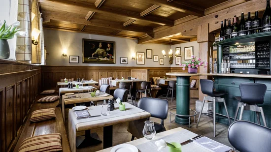 Gemütliches Restaurant mit Holzmöbeln, Barbereich und gedeckten Tischen