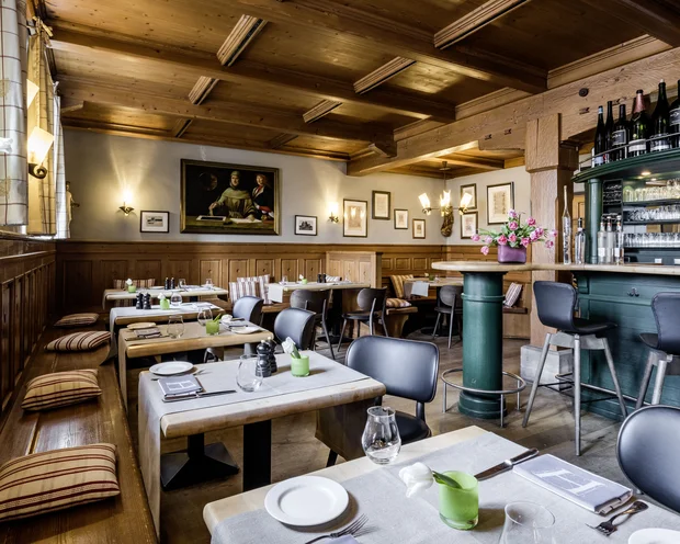 Gemütliches Restaurant mit Holzmöbeln, Barbereich und gedeckten Tischen