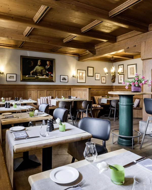 Gemütliches Restaurant mit Holzmöbeln, Barbereich und gedeckten Tischen