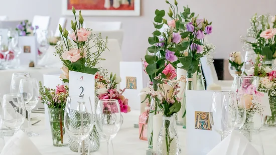 Festlich gedeckter Tisch mit Blumenarrangements und Weingläsern