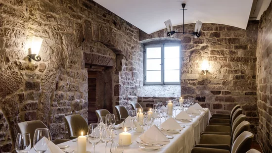 Eleganter Essraum mit Steinwänden und Kerzen auf einem gedeckten Tisch