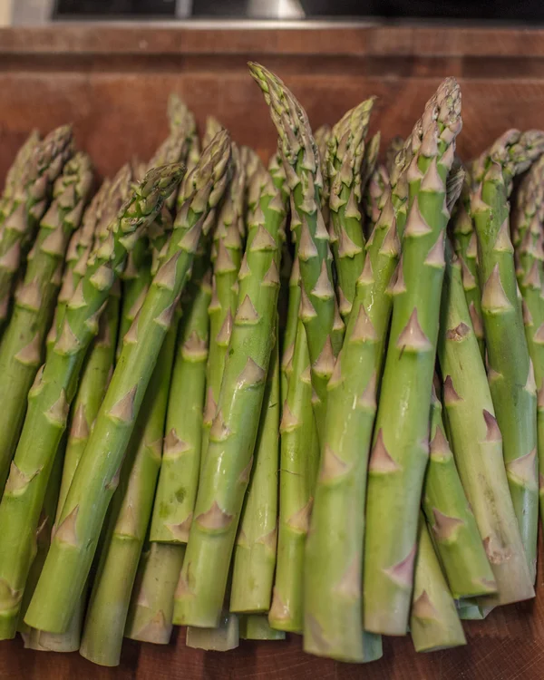 Frischer grüner Spargel auf einem Holzbrett