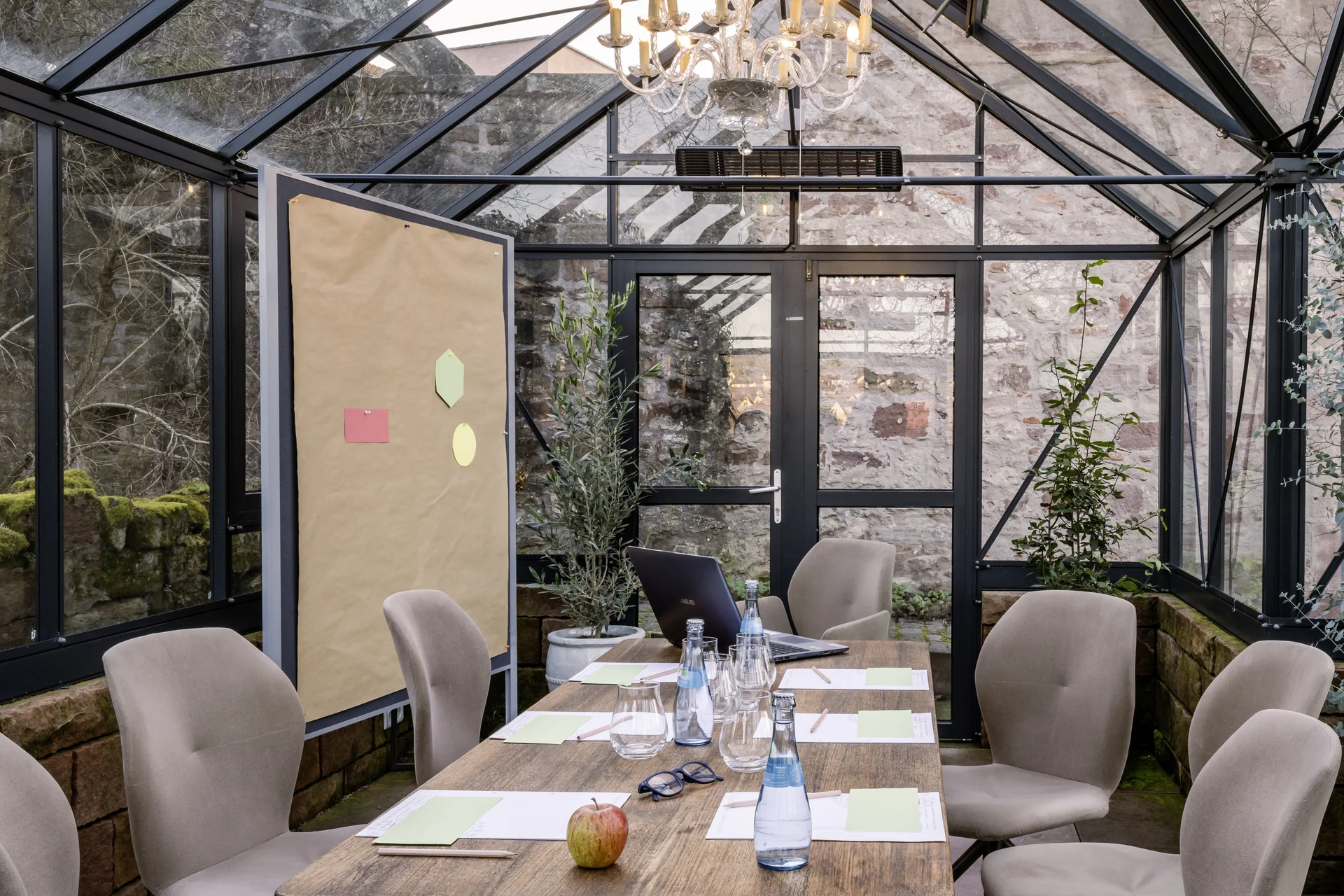 Konferenzraum im Gewächshaus mit Holztisch und beigen Stühlen