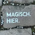 Stein mit weißer Aufschrift magisch hier auf Kopfsteinpflaster
