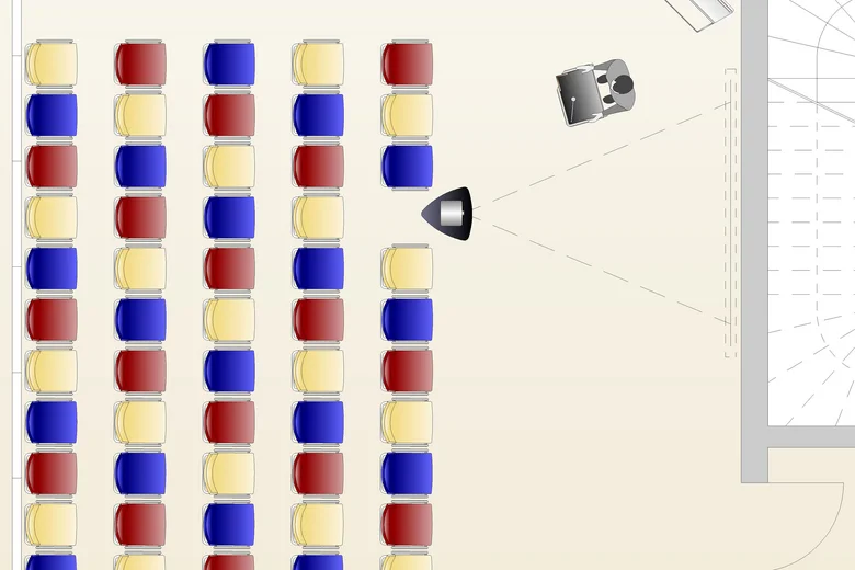 Theaterbestuhlung mit bunten Stuhlreihen und Projektor vor Bühne