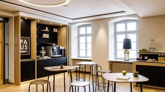 Modern eingerichteter Aufenthaltsraum mit Stehtischen, Kaffeemaschine und Dekoration