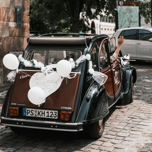 Hochzeitsauto mit Dekoration und Just Married Schild