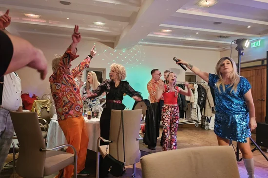 Sonntagsbrunch Menschen feiern und singen mit Mikrofon auf einer Party in bunten Outfits