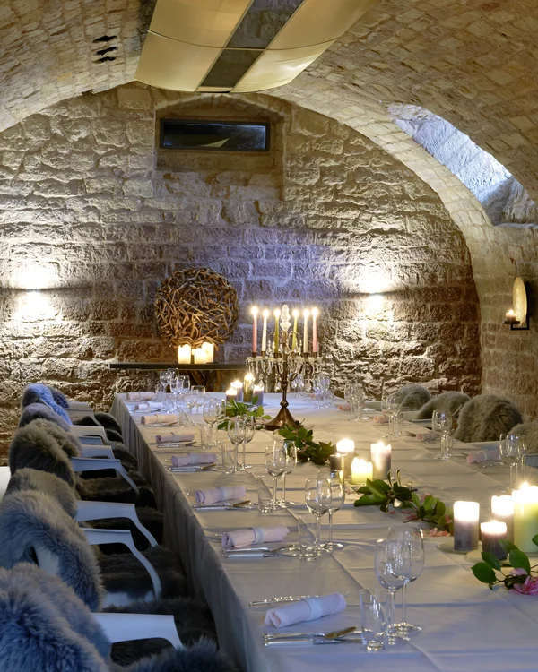 Eleganter Kerzenschein gedeckter Tisch in einem steinernen Gewölbekeller