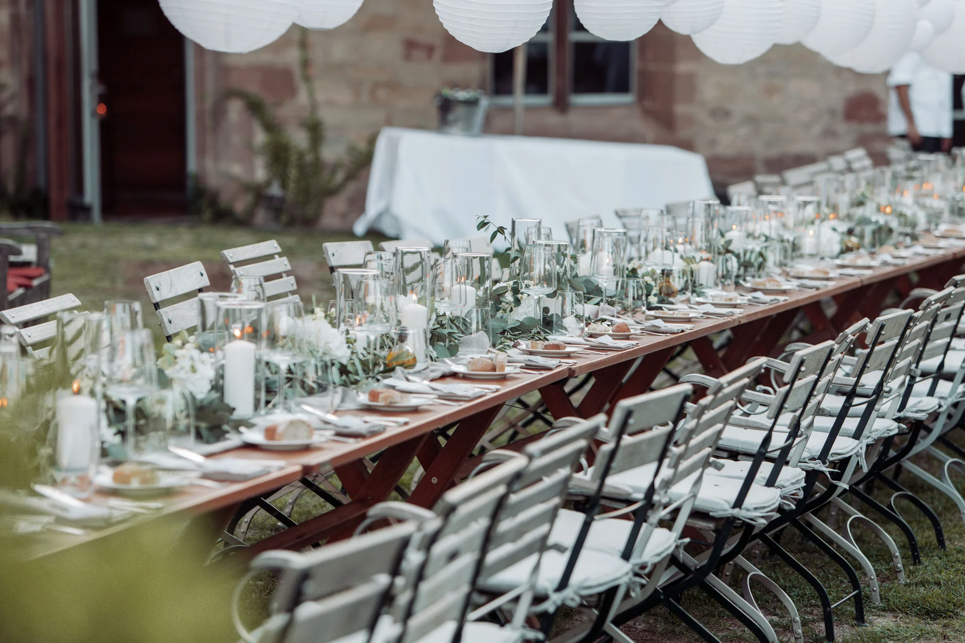 Lange Tischreihe mit Kerzen und Dekoration für festliches Outdoor-Essen