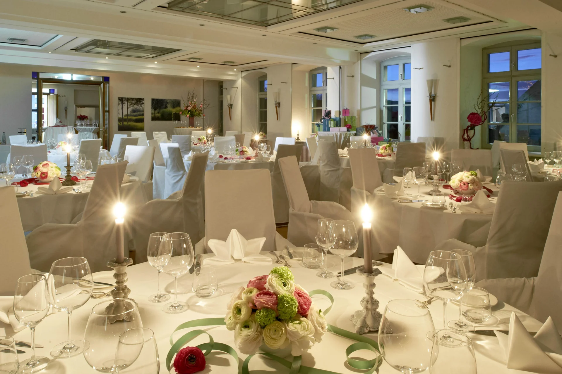 Eleganter Bankettsaal mit festlich gedeckten Tischen und Blumenarrangements