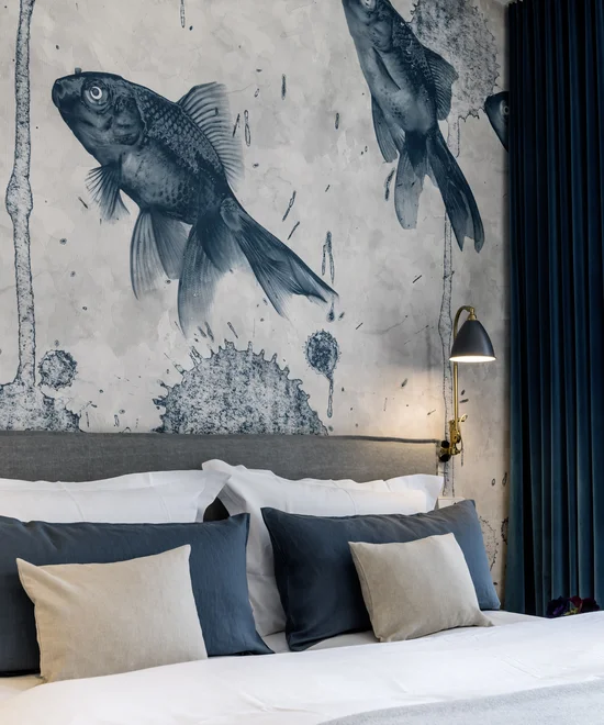Schlafzimmer mit Wandkunst in Form von großen Fischen über dem Bett