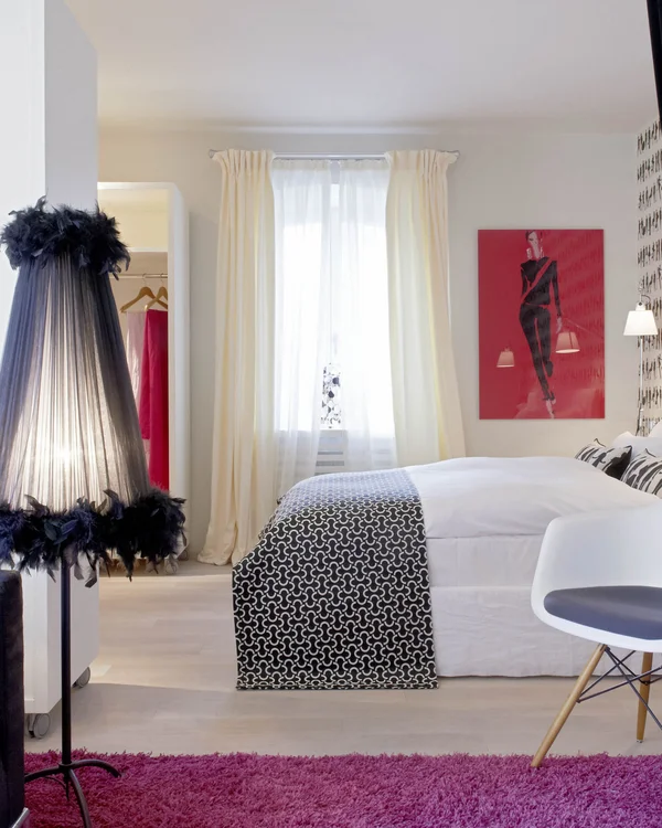 Modernes Schlafzimmer mit schwarz-weißem Dekor und lila Teppich