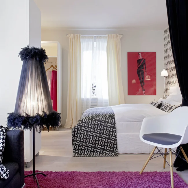 Modernes Schlafzimmer mit schwarz-weißem Dekor und lila Teppich