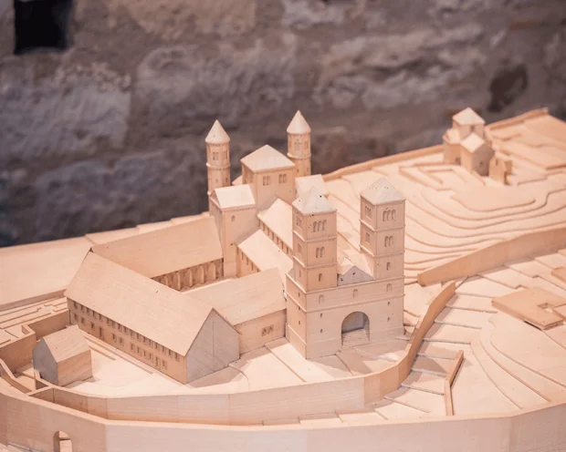 Modell eines historischen Klosterkomplexes aus Holz vor einer Steinmauer