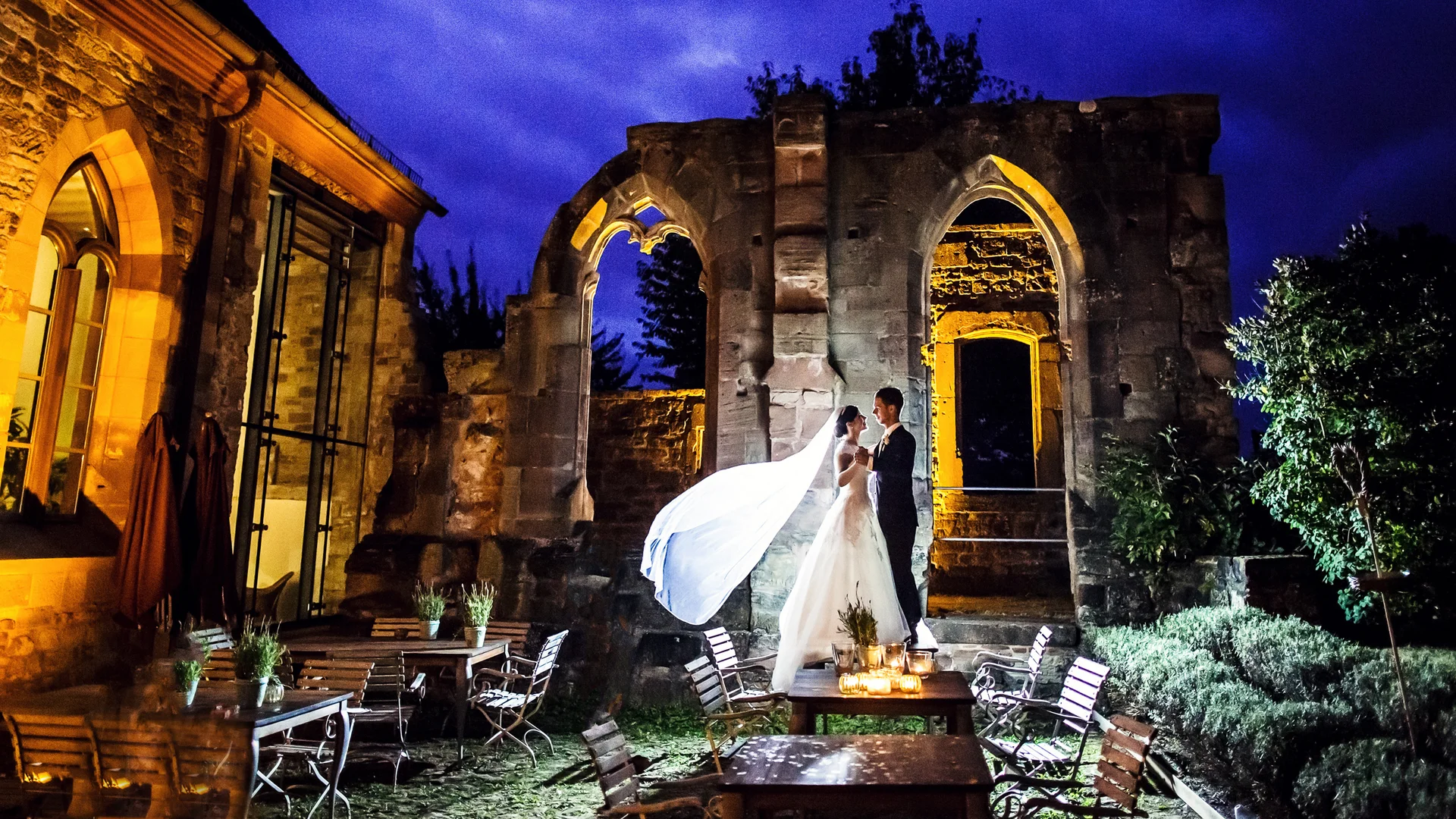Traumhochzeit im Kloster Hornbach | Ihre Hochzeitslocation | Saarland | Rheinland-Pfalz Brautpaar bei Nacht vor beleuchteten historischen Ruinen und Tischen