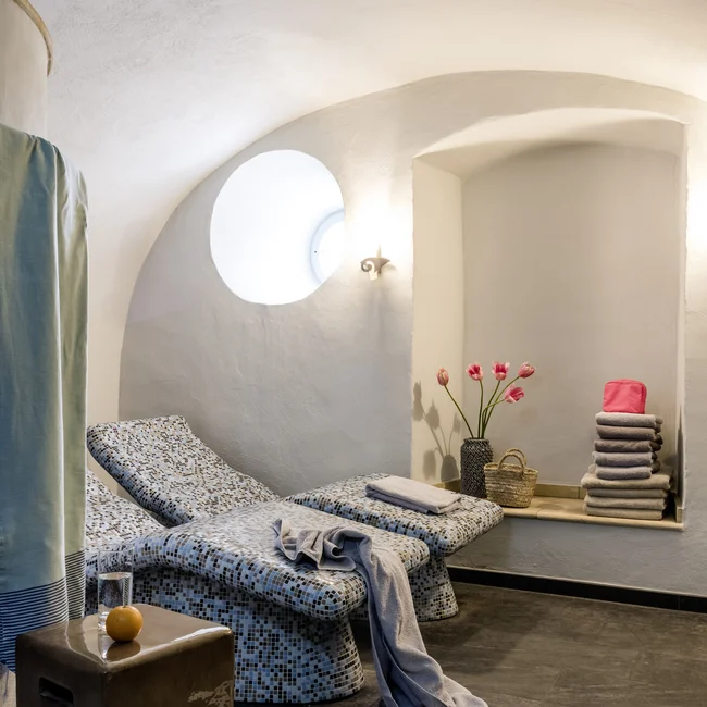 Ruheraum mit Liegestühlen, Handtüchern, Slippern und Blumen in modernem Design