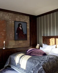 Gemütliches Schlafzimmer mit Vintage-Dekor, Steinwand und Bett mit gemustertem Überwurf