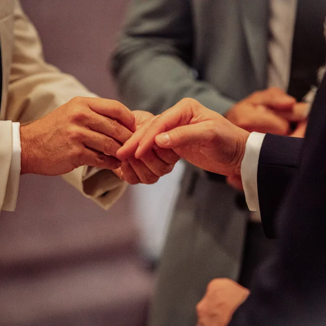 Beide Hände von zwei Personen in Anzügen beim Händedruck nah