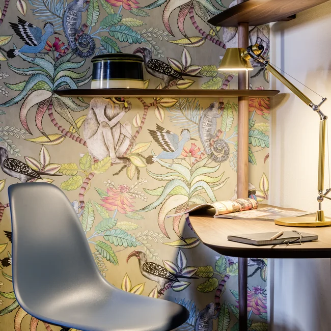 Moderner Arbeitsplatz mit bunter Wandtapete und Schreibtischlampe