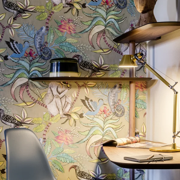 Moderner Arbeitsplatz mit bunter Wandtapete und Schreibtischlampe