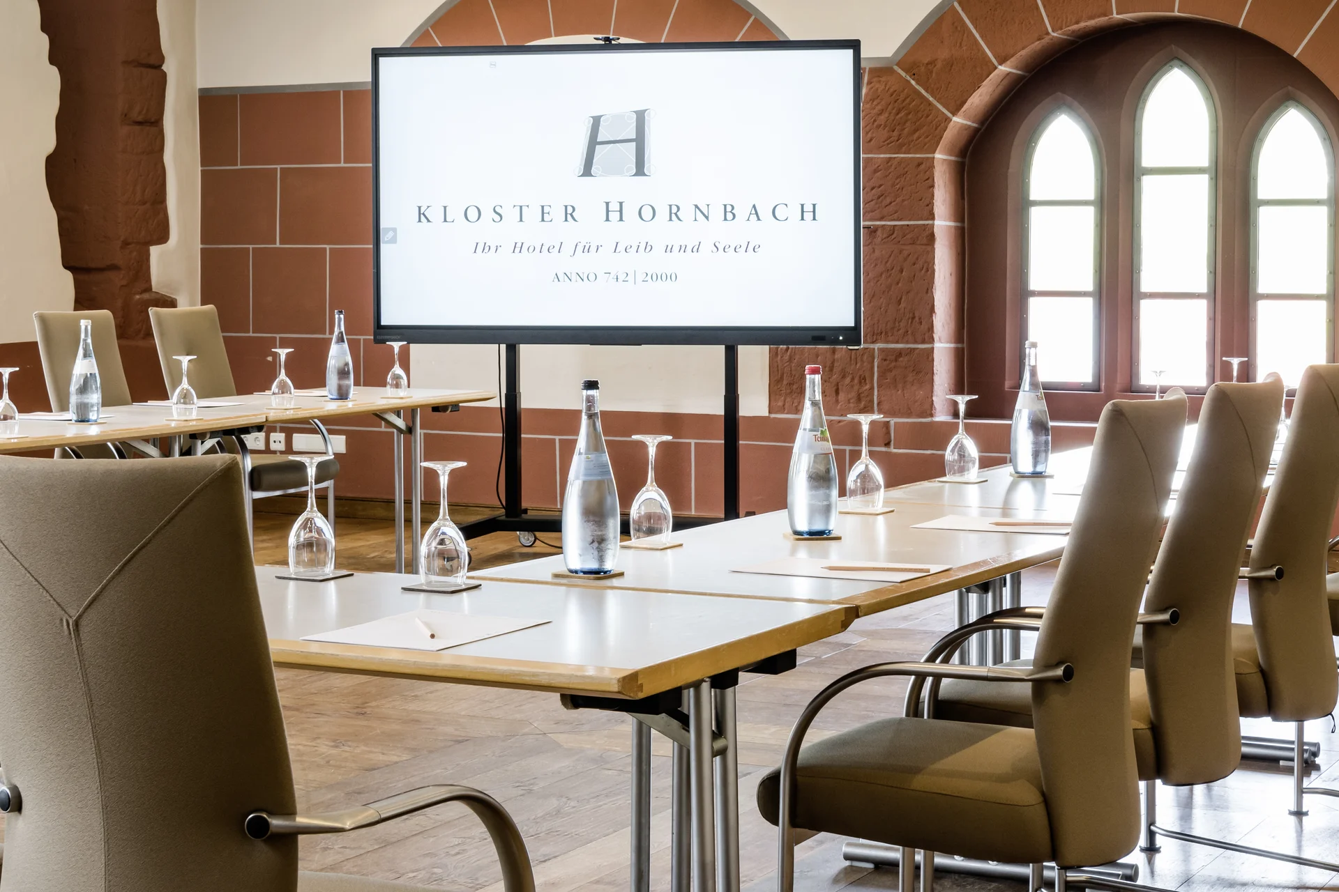 Moderner Konferenzraum mit Bildschirm und bestuhltem Tisch in Kloster Hornbach