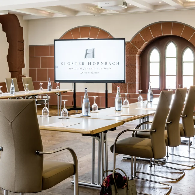 Moderner Konferenzraum mit Bildschirm und bestuhltem Tisch in Kloster Hornbach