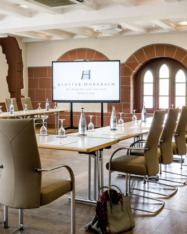 Moderner Konferenzraum mit Bildschirm und bestuhltem Tisch in Kloster Hornbach