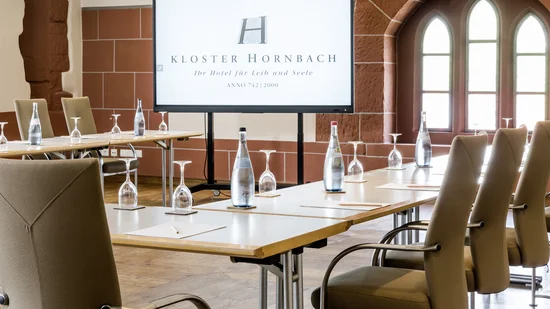 Moderner Konferenzraum mit Bildschirm und bestuhltem Tisch in Kloster Hornbach