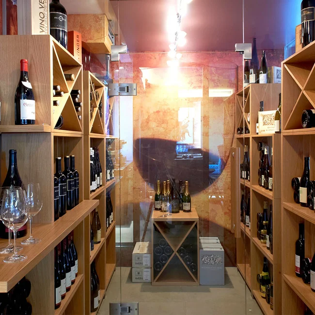 Weinkeller mit hölzernen Regalen und verschiedenen Weinflaschen