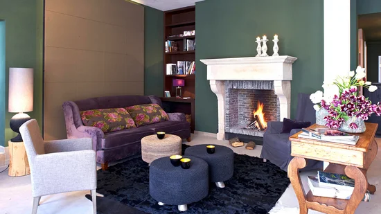 Gemütliches Wohnzimmer mit Kamin, Sofa, Sesseln und Couchtischen